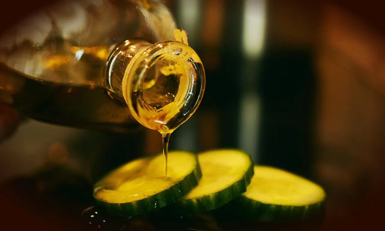 Bottle pouring virgin olive oil in a bowl close up